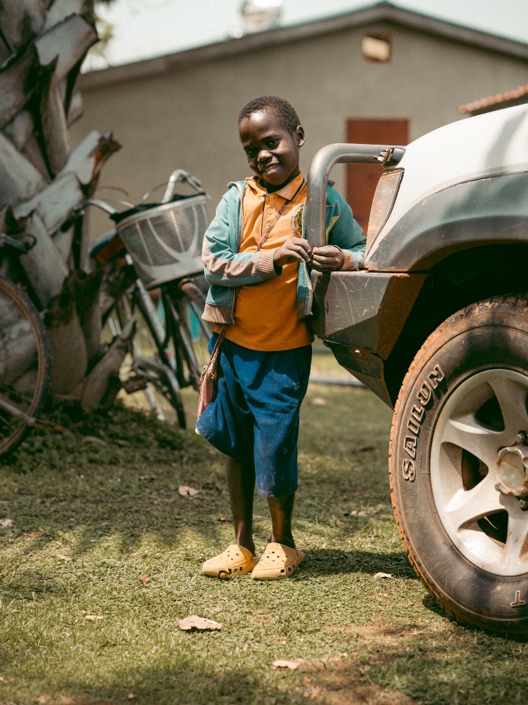 A child standing beside a vehicle